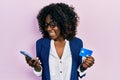 Young african american woman holding smartphone and credit card celebrating crazy and amazed for success with open eyes screaming Royalty Free Stock Photo