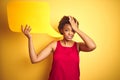 Young african american woman holding speech bubble over yellow isolated background stressed with hand on head, shocked with shame Royalty Free Stock Photo