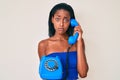 Young african american woman holding vintage telephone depressed and worry for distress, crying angry and afraid