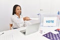 Young african american woman holding vote paper working at electoral college