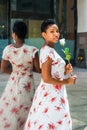 Young African American Woman holding white rose, waiting you by Royalty Free Stock Photo