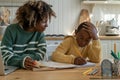 Young African American woman homeschool mom helping son with homework Royalty Free Stock Photo