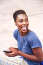 Young african american woman laughing with mobile phone outdoors Royalty Free Stock Photo