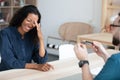 Young african american woman laughing, sitting in front of recruiter.