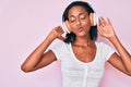 Young african american woman listening to music using headphones looking at the camera blowing a kiss being lovely and sexy Royalty Free Stock Photo