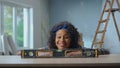 A young African American woman looks at the building bubble level with interest and smiles. A black woman uses a Royalty Free Stock Photo