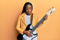 Young african american woman playing electric guitar clueless and confused expression Royalty Free Stock Photo