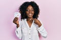 Young african american woman playing poker holding cards smiling happy pointing with hand and finger Royalty Free Stock Photo