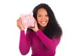 Young african american woman putting coin in piggy bank Royalty Free Stock Photo