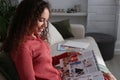 Young African-American woman reading fashion magazine at home Royalty Free Stock Photo