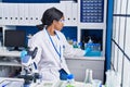 Young african american woman scientist using microscope working at laboratory Royalty Free Stock Photo
