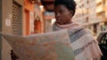 Young african american woman with serious expression holding city map at street Royalty Free Stock Photo