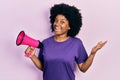 Young african american woman shouting through megaphone celebrating achievement with happy smile and winner expression with raised Royalty Free Stock Photo