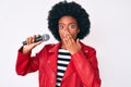 Young african american woman singing song using microphone covering mouth with hand, shocked and afraid for mistake Royalty Free Stock Photo