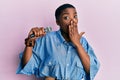 Young african american woman singing song using microphone covering mouth with hand, shocked and afraid for mistake Royalty Free Stock Photo