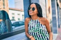 Young african american woman smiling happy leaning on the wall at the city Royalty Free Stock Photo