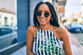 Young african american woman smiling happy leaning on the wall at the city Royalty Free Stock Photo