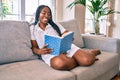 Young african american woman smiling happy reading book at home Royalty Free Stock Photo