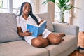 Young african american woman smiling happy reading book at home Royalty Free Stock Photo