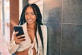 Young african american woman smiling happy using smartphone at the city Royalty Free Stock Photo