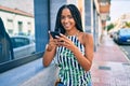 Young african american woman smiling happy using smartphone at the city Royalty Free Stock Photo