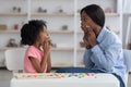 Speech-language pathologist having lesson with little girl