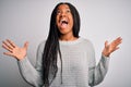 Young african american woman standing casual and cool over grey isolated background celebrating mad and crazy for success with Royalty Free Stock Photo