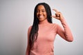 Young african american woman standing casual and cool over white isolated background smiling and confident gesturing with hand Royalty Free Stock Photo