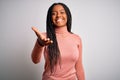 Young african american woman standing casual and cool over white isolated background smiling friendly offering handshake as Royalty Free Stock Photo