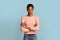 Young african american woman standing with folded arms over blue studio background Royalty Free Stock Photo