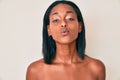 Young african american woman standing topless showing skin looking at the camera blowing a kiss being lovely and sexy Royalty Free Stock Photo