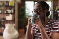 Young african american woman talking on smartphone, drinking tea Royalty Free Stock Photo
