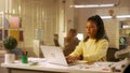 A young African American woman is texting on her mobile phone and smiling. The boss makes a remark and the black woman