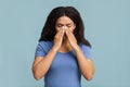 Young black woman touching her nose bridge, suffering from rhinitis, grey background Royalty Free Stock Photo