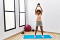 Young african american woman training using ketlebell at sport center