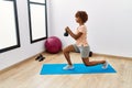 Young african american woman training using ketlebell at sport center