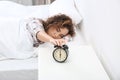 Young African-American woman turning off alarm clock at home. Royalty Free Stock Photo