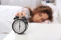 Young African-American woman turning off alarm clock Royalty Free Stock Photo