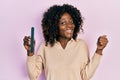 Young african american woman using file nail pointing thumb up to the side smiling happy with open mouth Royalty Free Stock Photo