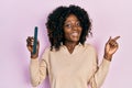 Young african american woman using file nail smiling happy pointing with hand and finger to the side Royalty Free Stock Photo