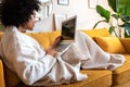 Young african american woman using laptop computer at home sitting on the sofa. Royalty Free Stock Photo