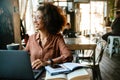 Young african american woman using laptop computer sitting in cafe Royalty Free Stock Photo