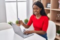 Young african american woman using laptop and credit card sitting on table at home Royalty Free Stock Photo