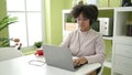 Young african american woman using laptop and headphones sitting on table at home Royalty Free Stock Photo