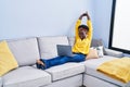 Young african american woman using laptop sitting on sofa at home Royalty Free Stock Photo