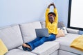 Young african american woman using laptop sitting on sofa at home Royalty Free Stock Photo