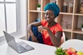 Young african american woman using laptop sitting on table at home Royalty Free Stock Photo