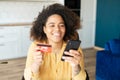 Young African-American woman using smartphone for shopping online Royalty Free Stock Photo