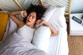 Young African American woman waking up in the morning, yawning and stretching arms in bed. Good morning. Royalty Free Stock Photo