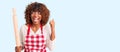 Young african american woman wearing apron holding rolling pin screaming proud, celebrating victory and success very excited with Royalty Free Stock Photo